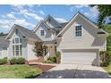 Charming two-story traditional home featuring a manicured lawn, attached garage, and welcoming entrance with brick steps at 103 Equestrian Ct, Cary, NC 27513