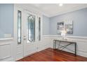 Elegant foyer with a decorative glass front door, hardwood floors, and wainscoting at 107 Sonoma Valley Dr, Cary, NC 27518