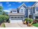 Charming two-story home featuring a two-car garage, a well-manicured lawn, and chairs on the front porch at 108 Ribbon Walk Ln, Holly Springs, NC 27540