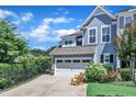 Charming home featuring a two-car garage and a well-manicured lawn, under a partly cloudy, bright blue sky at 108 Ribbon Walk Ln, Holly Springs, NC 27540