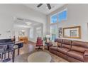 Bright and airy living room with large windows, hardwood floors, and a comfortable leather sofa at 108 Ribbon Walk Ln, Holly Springs, NC 27540