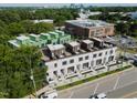 Aerial view of modern townhomes with rooftop patios and a nearby building in the distance at 1311 Chamblee Hill Ct, Raleigh, NC 27608