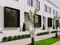 Modern brick townhomes with black-trimmed windows, sidewalk, and manicured landscaping at 1311 Chamblee Hill Ct, Raleigh, NC 27608
