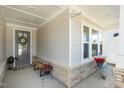 Cozy covered porch with stone accents, a bench, and decorative plants at 149 Ivory Ln, Raleigh, NC 27610