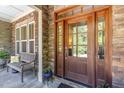 Inviting front porch with stone accents, a wooden bench, and a beautifully crafted front door at 150 Luxorwind Dr, Garner, NC 27529