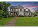 Charming two-story home features a well-manicured lawn, inviting front porch, and classic architectural details at 1505 Mclaurin Ln, Fuquay Varina, NC 27526