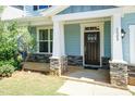 Inviting front porch with stone accents, leading to a dark wood front door and well-lit entry at 2008 Campana Dr, Raleigh, NC 27603