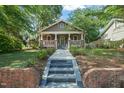 Inviting craftsman-style home with brick accents and a well-manicured lawn on a tree-lined street at 211 W Trinity Ave, Durham, NC 27701