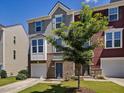 Townhome showing front yard with tree, with attached garage and brick details at 215 Brier Summit Pl, Durham, NC 27703