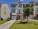Townhome showcasing manicured lawn, brick, garage, and inviting facade at 215 Brier Summit Pl, Durham, NC 27703