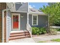 A welcoming entrance with a bright red door and brick steps leading to the front porch at 2208 Pathway Dr, Chapel Hill, NC 27516