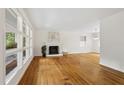 Spacious living room with a fireplace, hardwood floors, and large windows that flood the space with natural light at 2406 Oxford Rd, Raleigh, NC 27608