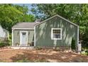 Inviting home with a welcoming front porch and beautifully landscaped yard, and green horizontal siding at 2410 Huron St, Durham, NC 27707