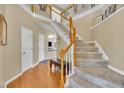Inviting entryway with hardwood floors, staircase with wood banister, and soaring ceilings at 2605 Bloomsberry Ridge Dr, Fuquay Varina, NC 27526