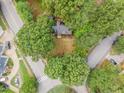 Aerial view of a gray roof home surrounded by mature trees and quiet residential street at 301 N King Charles Rd, Raleigh, NC 27610