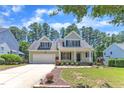 Traditional home with a well-kept lawn, front porch, and attached two-car garage in a friendly neighborhood at 305 Avent Meadows Ln, Holly Springs, NC 27540