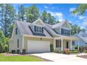 Charming home with a well-manicured lawn, inviting front porch, and attached two-car garage at 305 Avent Meadows Ln, Holly Springs, NC 27540