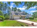 Inviting home with a lush lawn, mature trees, and an attached two-car garage at 305 Avent Meadows Ln, Holly Springs, NC 27540