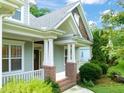Elegant front porch showcasing refined columns, brick detailing, and pristine landscaping at 322 Bellemont Rd, Pittsboro, NC 27312