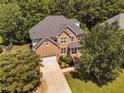 Beautiful aerial view of a home with mature trees, lush landscaping, and ample parking at 406 Dairy Farm Dr, Hillsborough, NC 27278