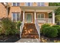 Welcoming front porch with brick steps and white railings, perfect for relaxing at 406 Dairy Farm Dr, Hillsborough, NC 27278