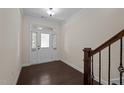 Bright foyer boasts dark hardwood floors and a staircase with a wooden railing at 469 Methven Grove Dr, Cary, NC 27519