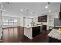 Open kitchen features stainless appliances, a center island, and dark hardwood flooring at 469 Methven Grove Dr, Cary, NC 27519