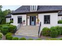 Elegant front entrance with stone steps, landscaped bushes, and a powder blue front door at 4725 Saratoga Falls Ln, Raleigh, NC 27614