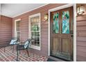 Inviting front porch with brick flooring and decorative glass front door at 4816 Marlborough Way, Durham, NC 27713