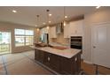 Bright, modern kitchen with large island, stainless steel appliances, pendant lights, and white cabinetry at 5031 Se Jowetts Walk Dr # 28, Cary, NC 27519