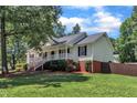 Inviting home with a covered front porch, surrounded by lush greenery and a well-kept lawn at 52 Malcolm Dr, Clayton, NC 27520