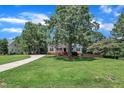 Well-maintained home with a lush lawn and mature trees, showcasing a long driveway and inviting curb appeal at 52 Malcolm Dr, Clayton, NC 27520
