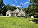 Beautiful home with well-manicured lawn, flagpole, and storage shed in a serene, wooded setting at 55 Ridge Haven Dr, Louisburg, NC 27549
