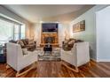 Bright living room boasts hardwood floors, cozy seating arrangements, a brick fireplace, and recessed lighting at 6501 Battleford Dr, Raleigh, NC 27613