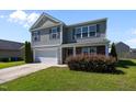 Charming two-story home with gray siding, complemented by a well-manicured front yard and a two car garage at 737 Botanical Ct, Bunnlevel, NC 28323