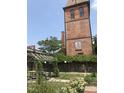 Exterior of brick building features a garden area with pergola and seating area at 807 W Trinity Ave # 209, Durham, NC 27701