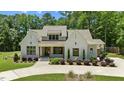 Charming white brick home with a well-manicured lawn, beautiful landscaping, and a welcoming entrance at 8420 Bells Lake Rd, Apex, NC 27539