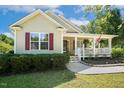 Inviting single Gathering home featuring a quaint front porch, red shutters, and well-maintained lawn at 86 Basswood Cir, Willow Springs, NC 27592