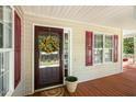 Welcoming front porch showcasing a charming entrance door, red shutters, and cozy outdoor space at 86 Basswood Cir, Willow Springs, NC 27592