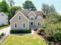 Classic tan home with well-manicured lawn, trim landscaping, and mature shade trees at 917 Haddon Hall Dr, Apex, NC 27502