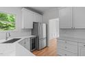 Bright kitchen with stainless steel appliances, white cabinets, and quartz countertops, offering a clean, modern aesthetic at 105 Greenbriar Ct, Chapel Hill, NC 27516