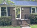 Close-up of brick home's front entrance with charming black shutters and a welcoming brick staircase at 108 Shadowbrook Dr, Hillsborough, NC 27278