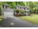 Home featuring an attached garage and inviting front porch framed by lush greenery at 10836 Wilmore Dr, Raleigh, NC 27614