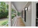 Inviting covered front porch with wood flooring and classic white railing at 10836 Wilmore Dr, Raleigh, NC 27614