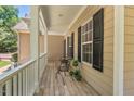 This covered front porch has white rails and black shutters for a sophisticated look and outdoor seating at 126 Captains Ct, Durham, NC 27712