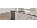 Kitchen island featuring stainless steel dishwasher, granite countertops, and white cabinets at 130 Rusling Leaf Dr, Fuquay Varina, NC 27526