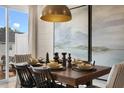 Dining room with a decorative chandelier and rustic table set for a meal, with a painting, a window, and chairs at 135 Siebold St, Garner, NC 27529