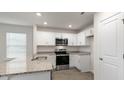 Bright kitchen featuring white cabinets, stainless steel appliances, granite countertops, and recessed lighting at 146 Rusling Leaf Dr, Fuquay Varina, NC 27526