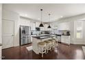 Bright kitchen featuring stainless appliances, white cabinetry, dark hardwood floors, and a breakfast bar with seating at 175 Hawkesburg Dr, Clayton, NC 27527