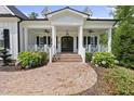 Inviting covered porch with brick flooring, white railings, and detailed trim work at 175 Stonecrest Way, Pittsboro, NC 27312